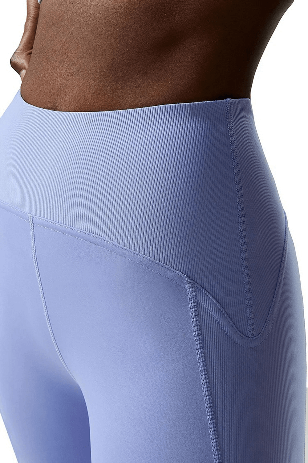 Close-up of women's light blue yoga leggings with ribbed waistband, made from comfortable nylon-spandex blend for versatile activewear.